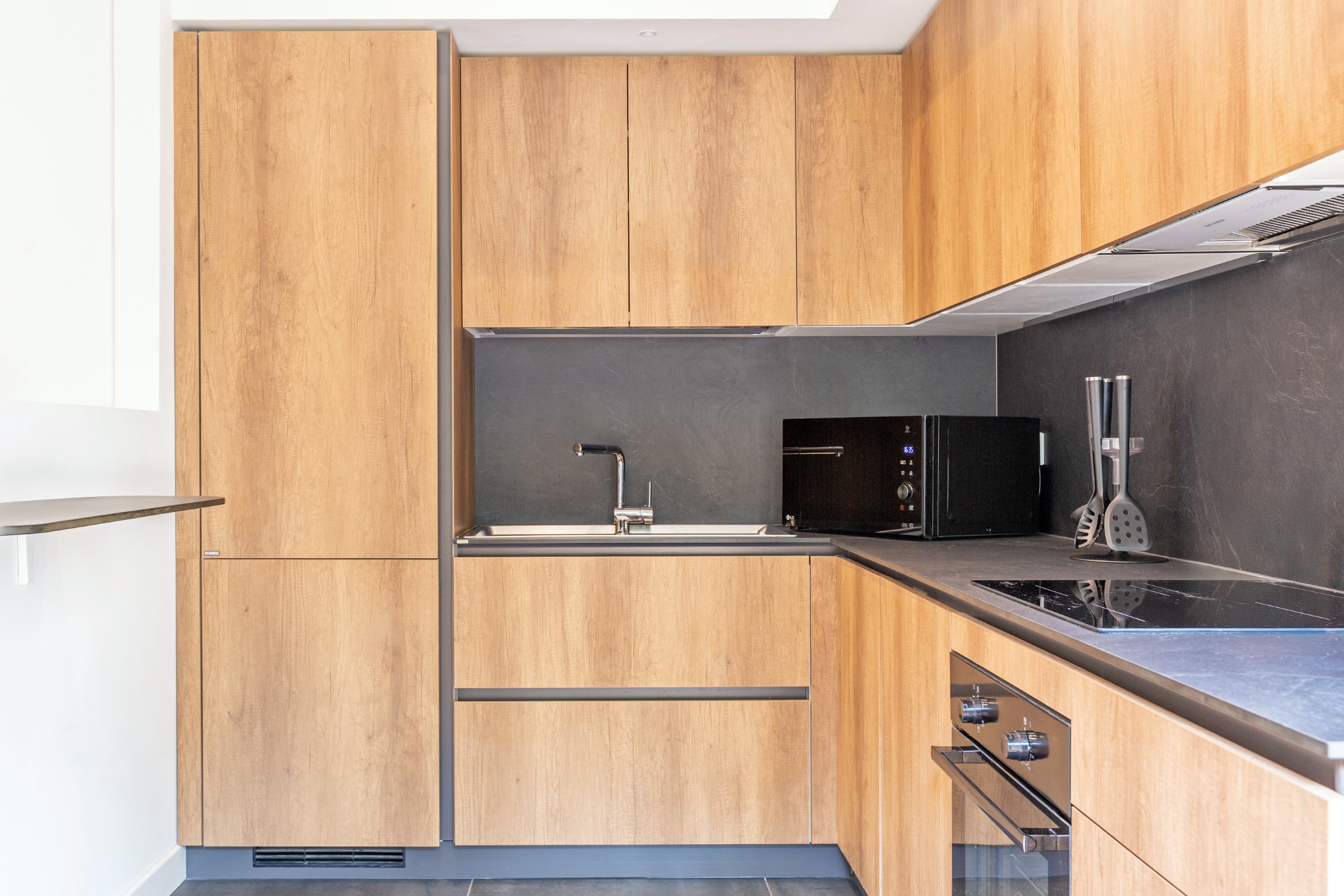 Cucina in legno naturale con superfici scure effetto pietra
