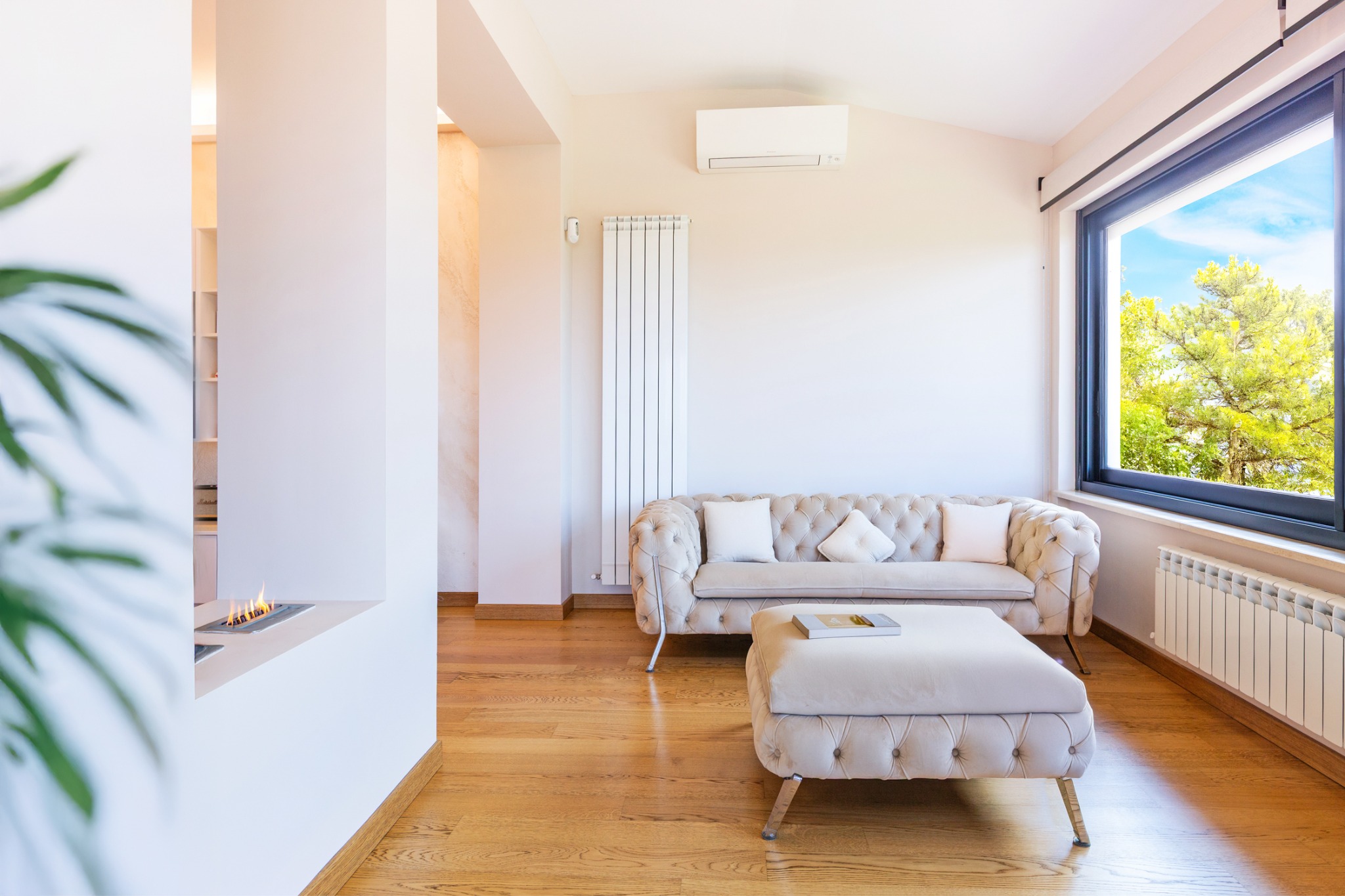 Salotto luminoso con divano capitonné e pouf coordinato