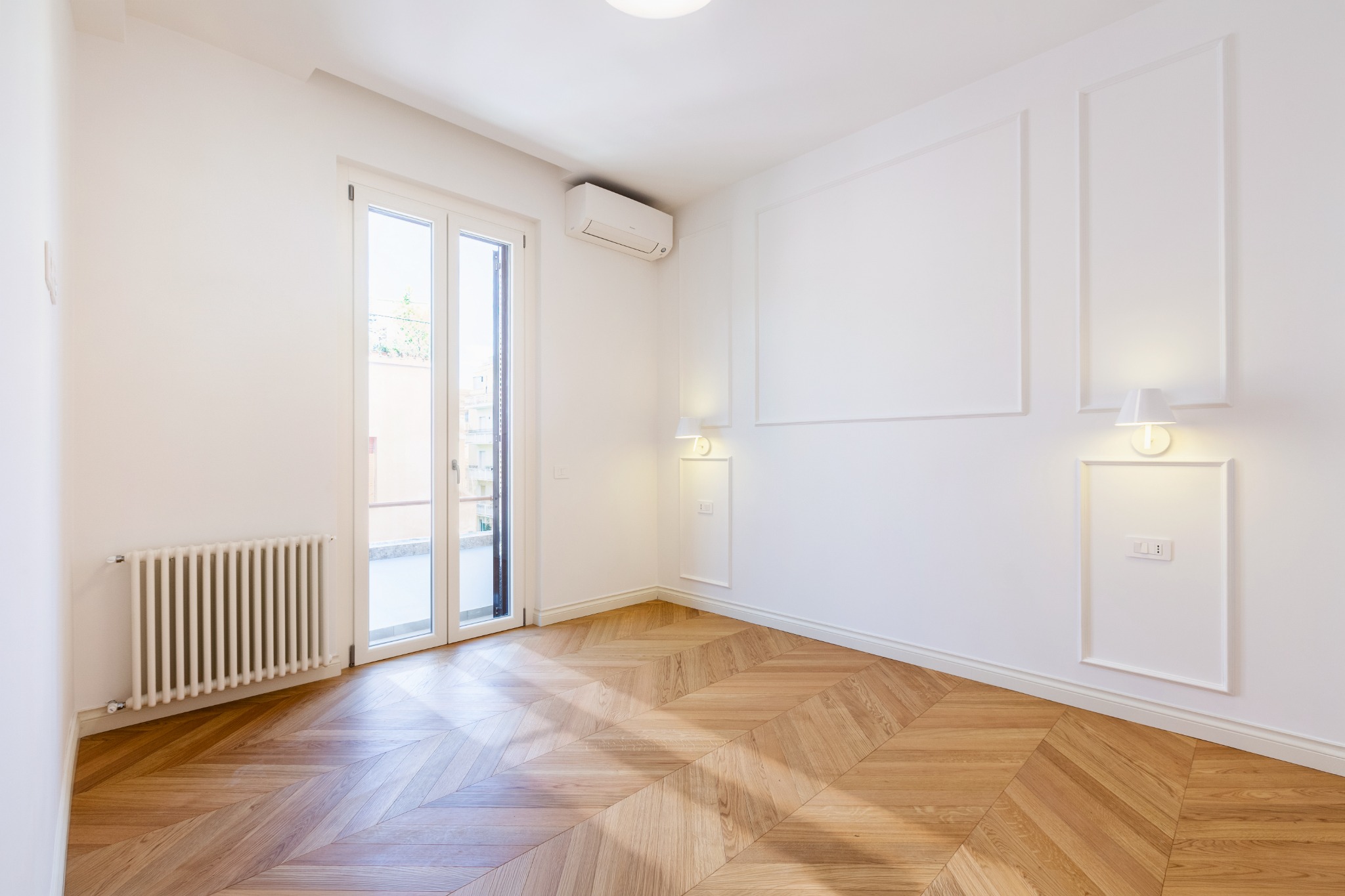 Camera luminosa con boiserie e parquet a spina di pesce